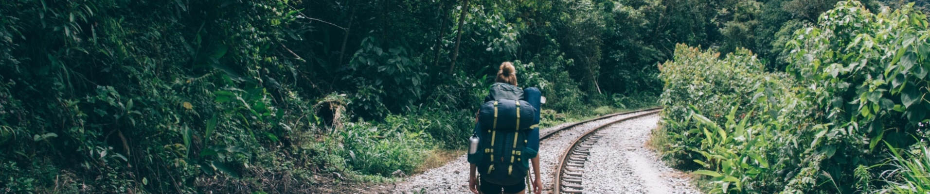 Femme randonnant sur les rails en direction du Machu Picchu